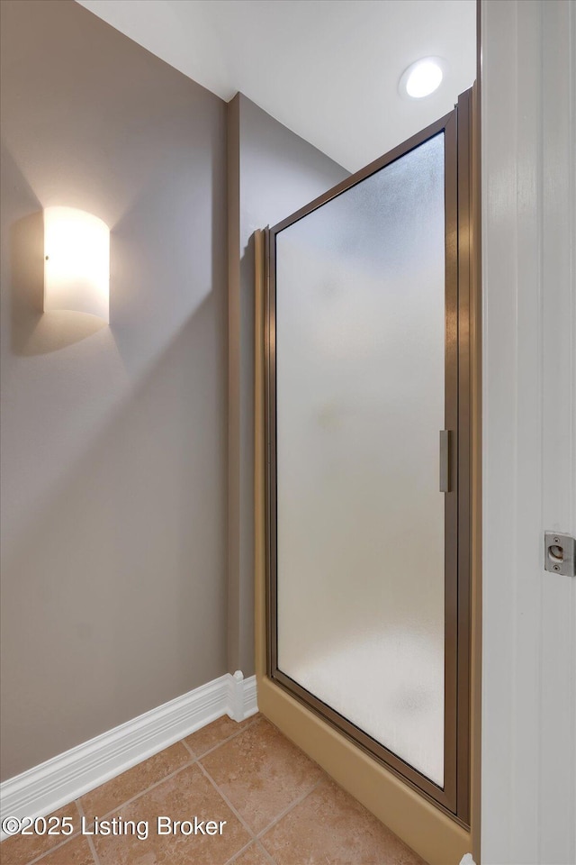 bathroom featuring a stall shower, baseboards, and tile patterned floors