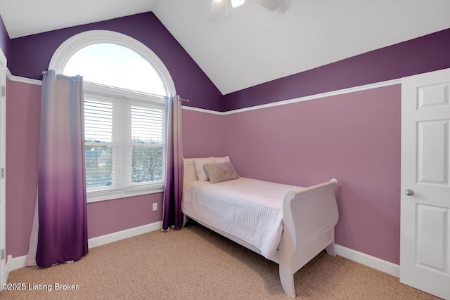 bedroom featuring light carpet, vaulted ceiling, baseboards, and ceiling fan