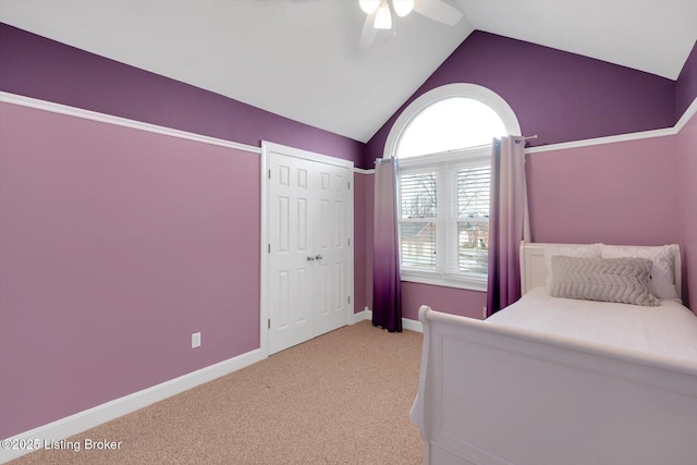 unfurnished bedroom featuring carpet, baseboards, vaulted ceiling, and a ceiling fan