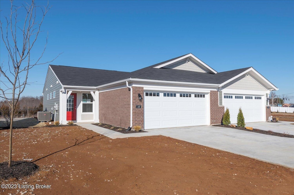 view of front facade with brick siding, central air condition unit, a shingled roof, concrete driveway, and an attached garage