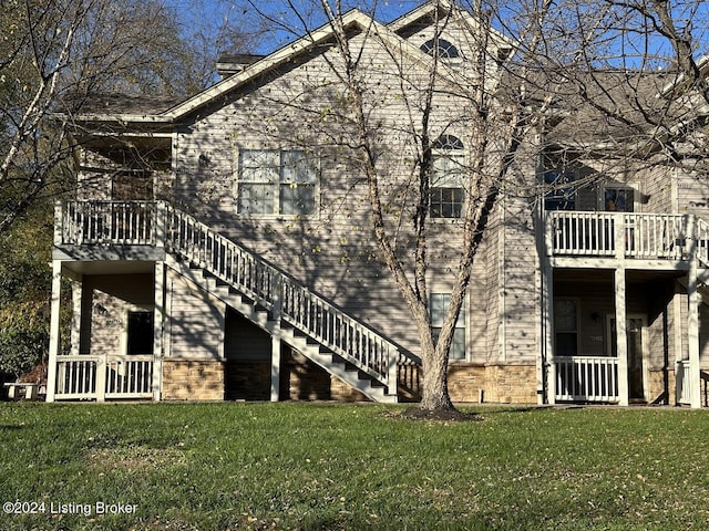 view of side of home with stairway and a lawn