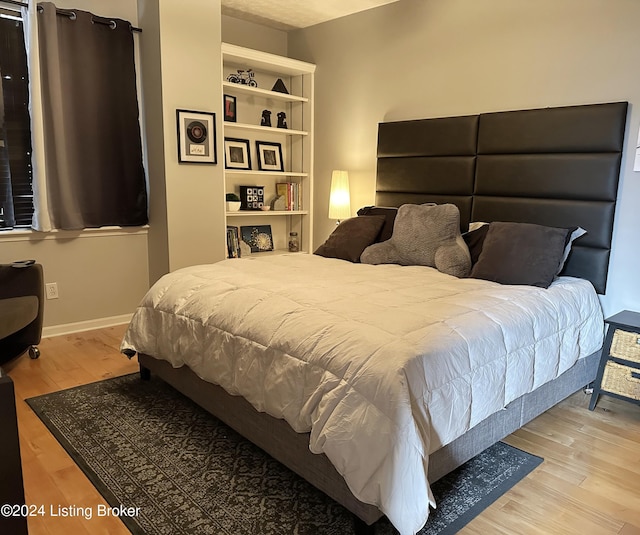 bedroom featuring baseboards and wood finished floors