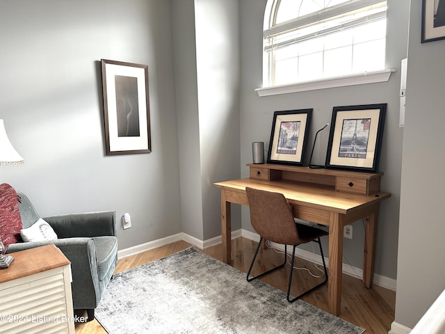 home office with baseboards and wood finished floors