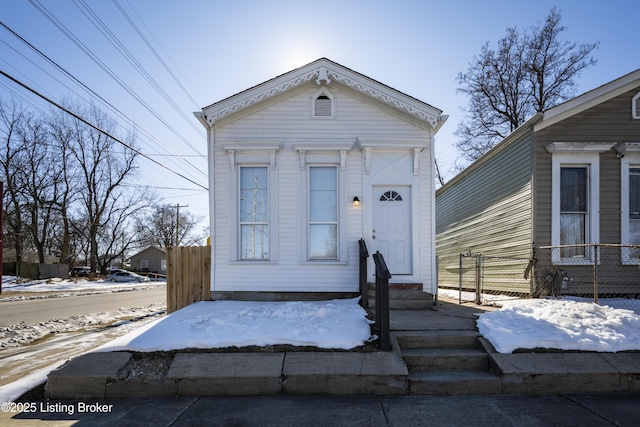 shotgun-style home with entry steps and fence