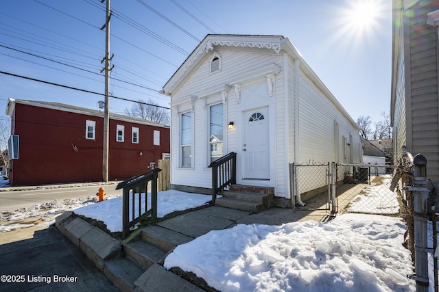 shotgun-style home featuring entry steps and fence