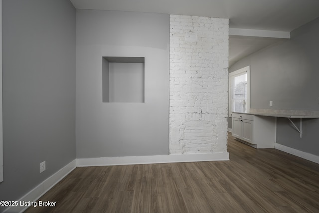 spare room with dark wood-style floors and baseboards