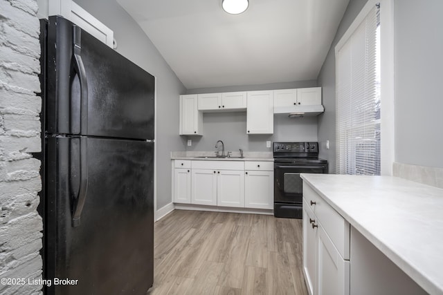 kitchen with under cabinet range hood, light countertops, black appliances, white cabinetry, and a sink