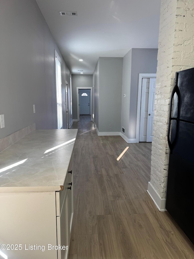 kitchen featuring dark wood finished floors, visible vents, freestanding refrigerator, white cabinetry, and baseboards