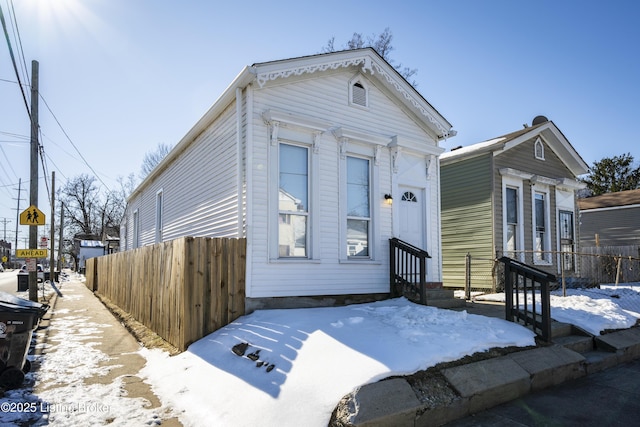 shotgun-style home featuring entry steps and fence