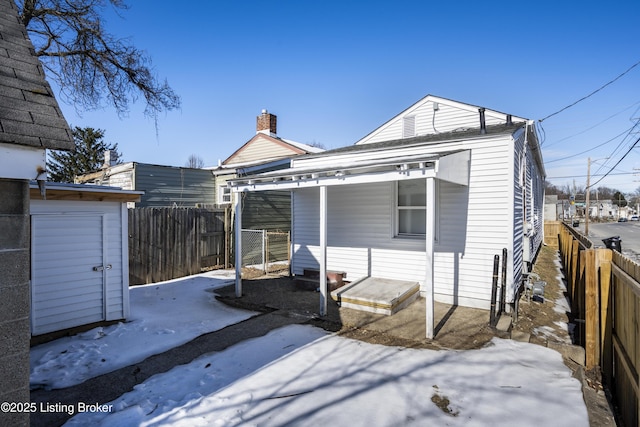 rear view of property featuring an outbuilding, a fenced backyard, and a storage shed