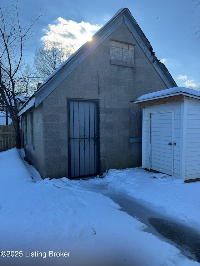 exterior space featuring an outbuilding, a storage shed, and concrete block siding