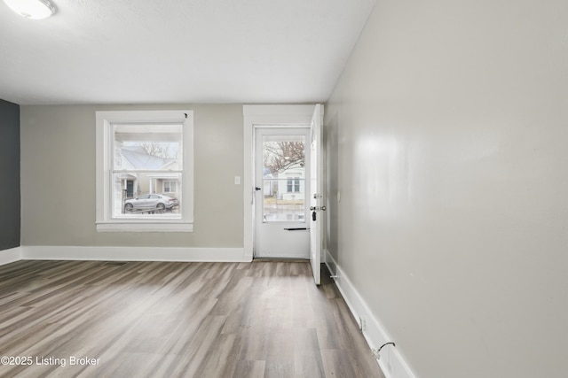 doorway to outside with wood finished floors and baseboards