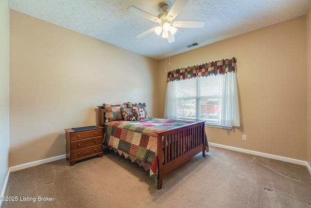 carpeted bedroom with visible vents, ceiling fan, a textured ceiling, and baseboards