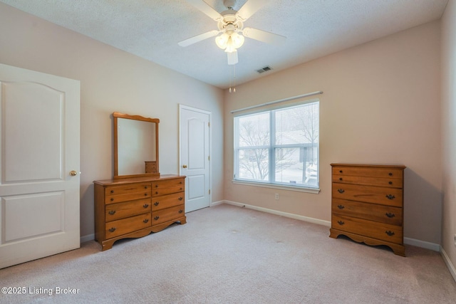 bedroom with carpet flooring, visible vents, baseboards, and a textured ceiling