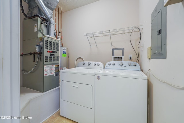 clothes washing area featuring heating unit, water heater, washing machine and dryer, laundry area, and electric panel