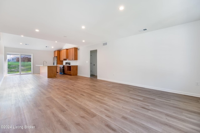 unfurnished living room featuring light wood finished floors, recessed lighting, visible vents, and baseboards