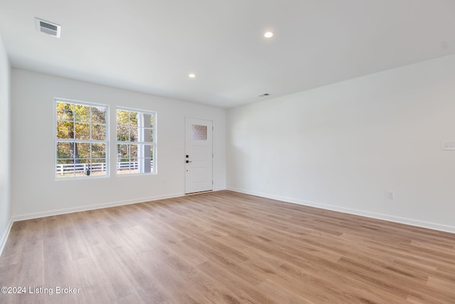 spare room with light wood-style floors, visible vents, baseboards, and recessed lighting