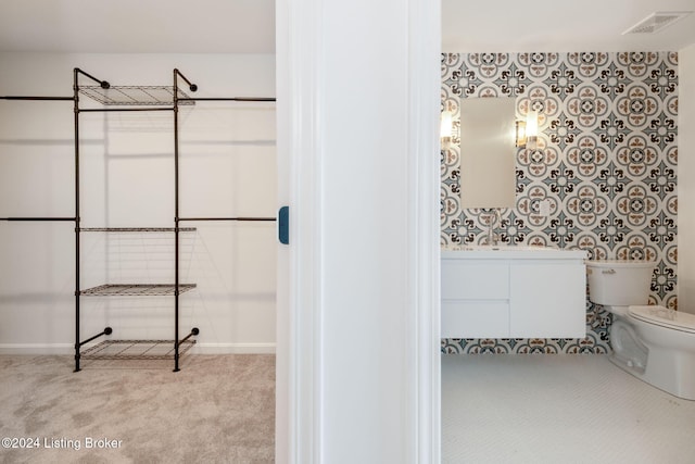 bathroom featuring toilet, baseboards, visible vents, and vanity