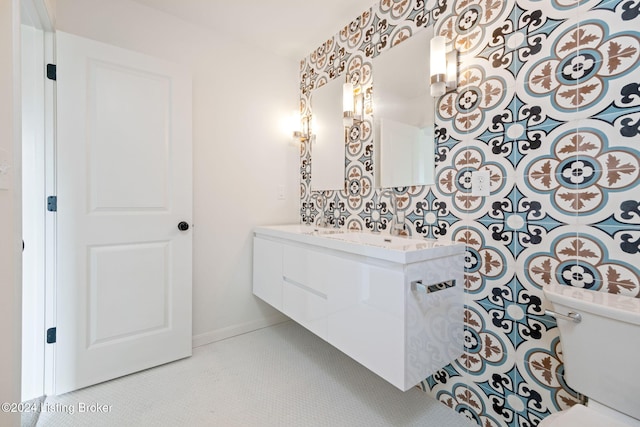 bathroom featuring toilet, baseboards, and vanity