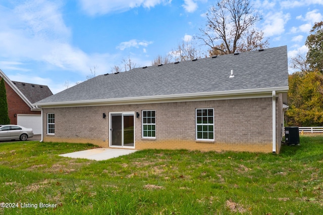 rear view of property with a shingled roof, a patio area, brick siding, and a yard