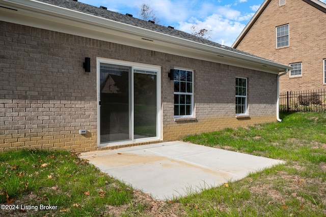 back of property featuring a patio area, fence, and brick siding