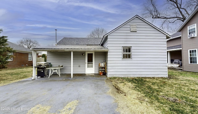 rear view of house featuring a yard, metal roof, and a patio