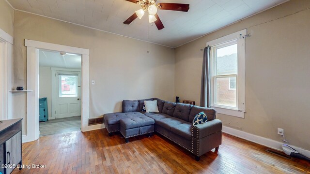 living area with a ceiling fan, baseboards, visible vents, and wood-type flooring