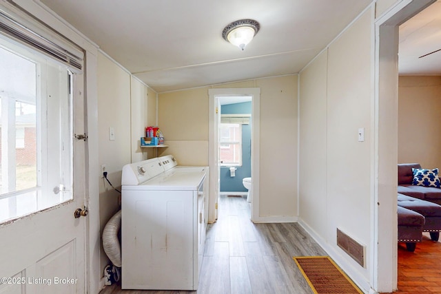 laundry area featuring light wood-type flooring, washer / dryer, laundry area, and visible vents