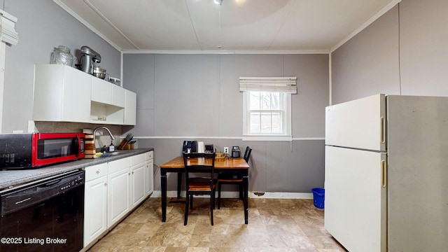 kitchen with black dishwasher, ornamental molding, freestanding refrigerator, white cabinets, and a sink