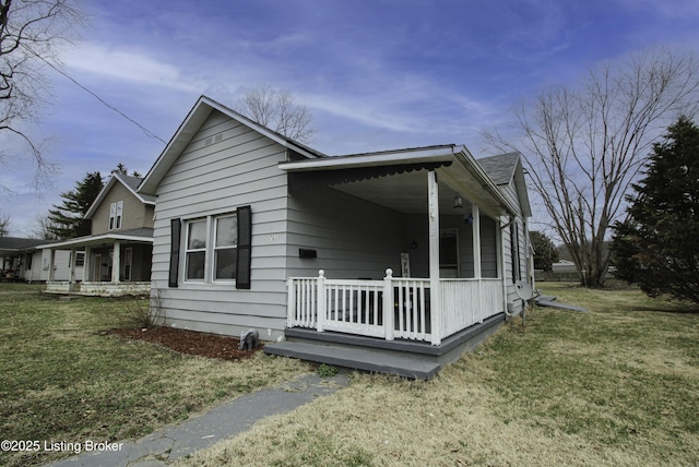 view of side of home with a lawn and covered porch