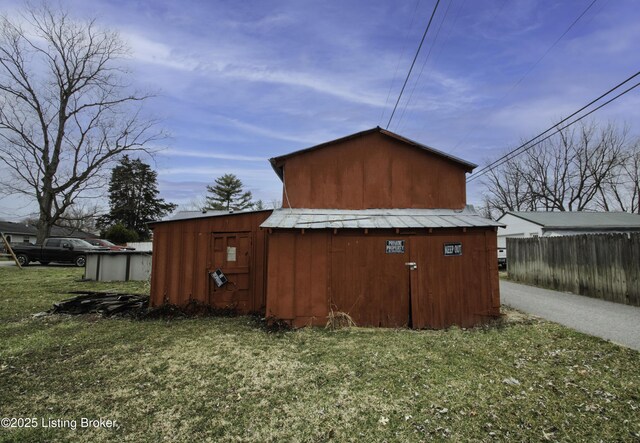 view of outbuilding featuring an outdoor structure and fence