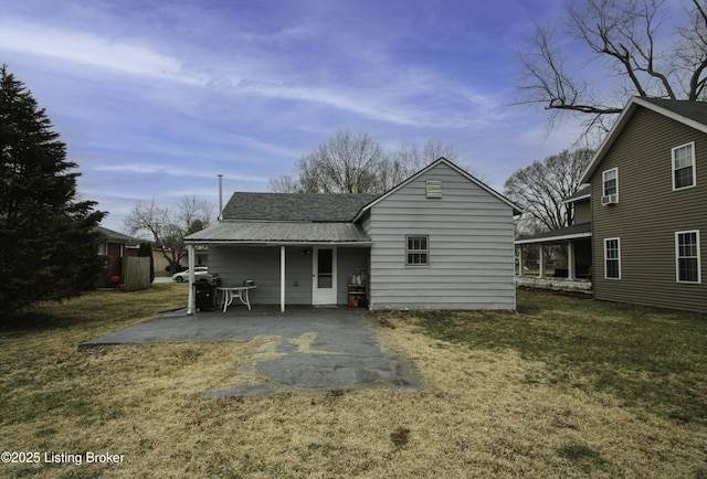 back of house with a patio area, metal roof, and a yard