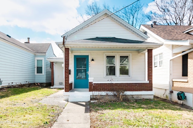 view of front of property featuring roof with shingles and a front yard