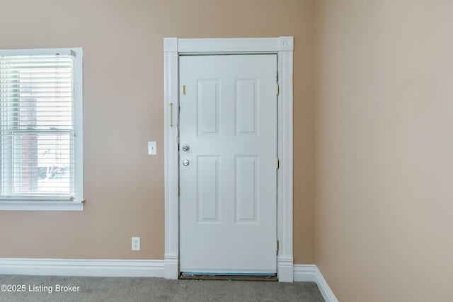 doorway to outside with carpet flooring and baseboards