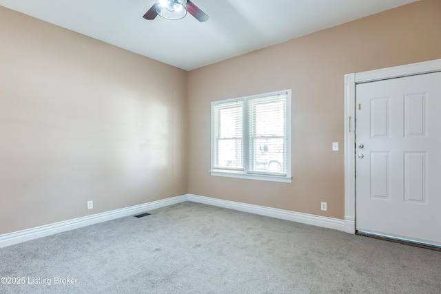 carpeted empty room with visible vents, ceiling fan, and baseboards