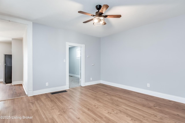 unfurnished room featuring light wood-type flooring, visible vents, ceiling fan, and baseboards