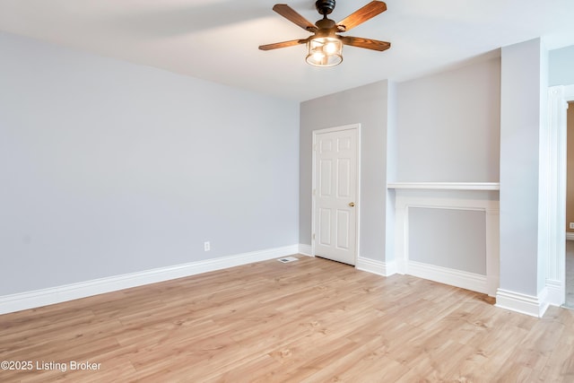 empty room featuring light wood-style floors, baseboards, and a ceiling fan