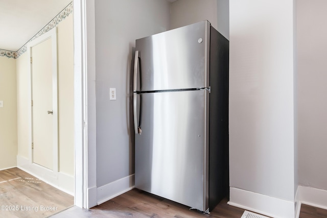 kitchen featuring wood finished floors, freestanding refrigerator, and baseboards