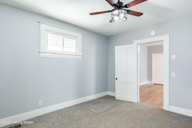 empty room with ceiling fan, baseboards, and carpet flooring