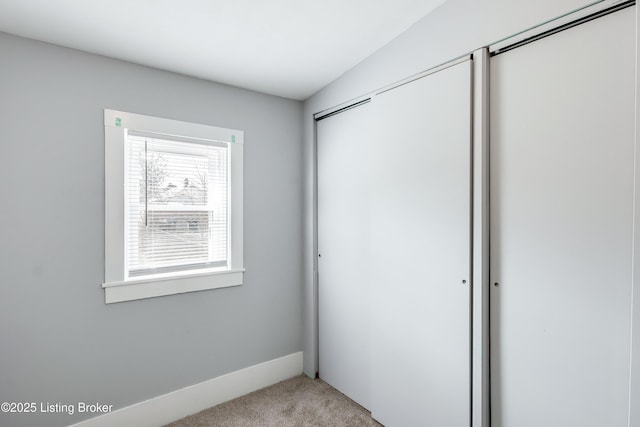 unfurnished bedroom with a closet and light carpet