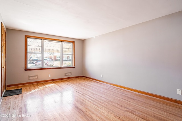 spare room with light wood-type flooring and baseboards