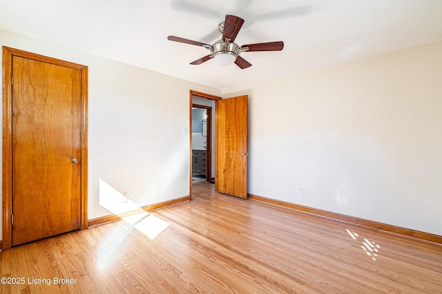 unfurnished room featuring a ceiling fan, light wood-type flooring, and baseboards