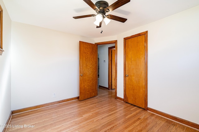 empty room with baseboards, ceiling fan, and light wood finished floors