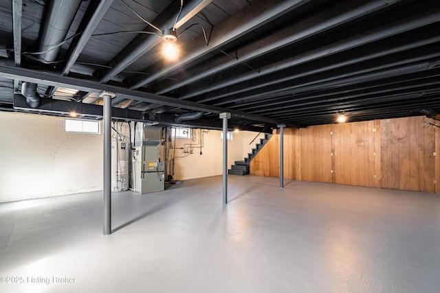 basement with heating unit, stairs, and gas water heater