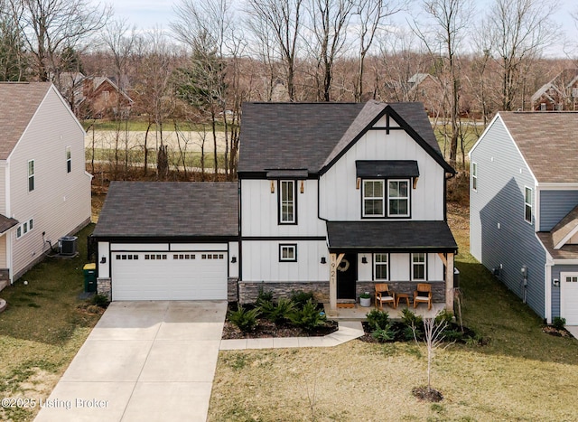 modern farmhouse with stone siding, a porch, board and batten siding, and concrete driveway