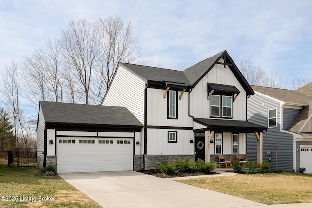 view of front of house with a garage, stone siding, board and batten siding, and driveway