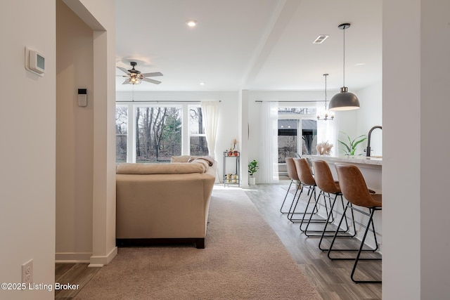 living area featuring baseboards, a ceiling fan, wood finished floors, and recessed lighting