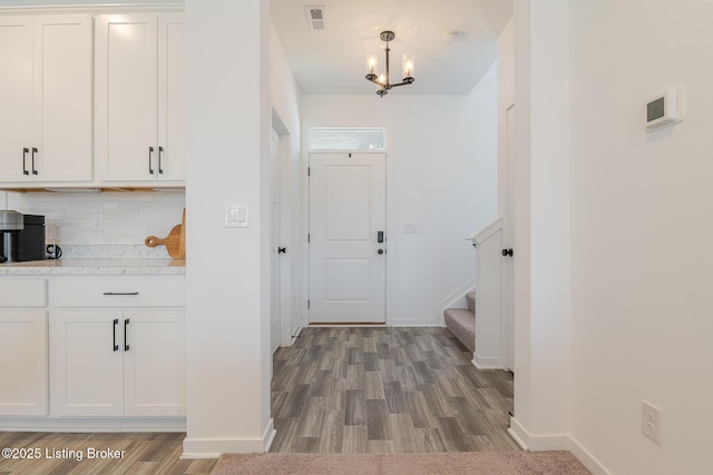 interior space with light wood-style floors, visible vents, and baseboards