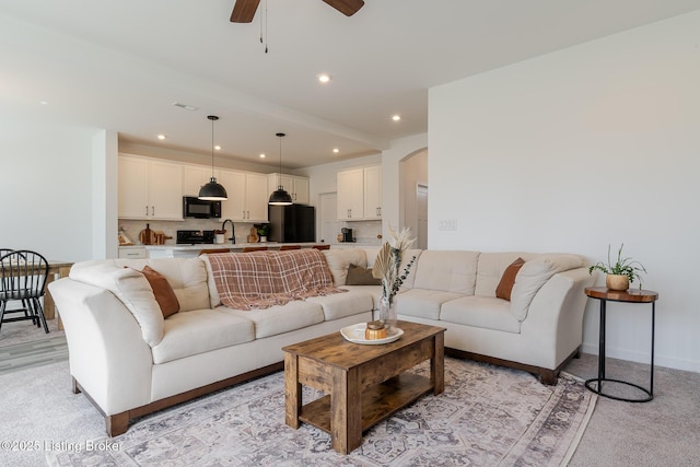 living area featuring ceiling fan, arched walkways, baseboards, and recessed lighting