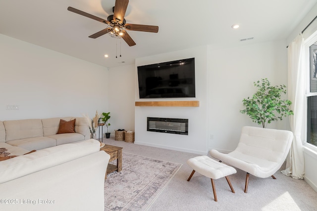 living room featuring recessed lighting, carpet flooring, visible vents, a ceiling fan, and a glass covered fireplace